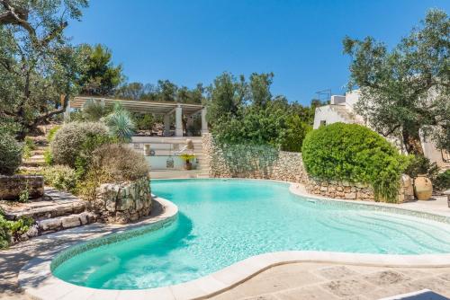 einen Pool in einem Garten mit Bäumen in der Unterkunft Il Trullo - Tia Maria Country Inn in Racale