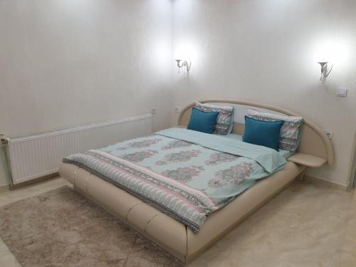 a bedroom with a bed with blue pillows on it at Safi in Dospat