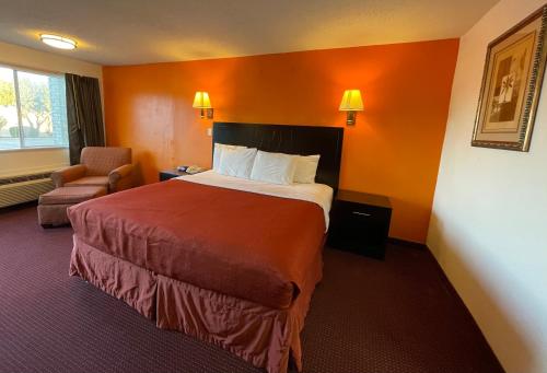 una habitación de hotel con una cama grande y una silla en Antilley Inn, en Abilene
