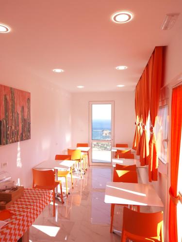 a restaurant with tables and chairs and a window at Bouganville Bed & Breakfast Stegna in Archangelos