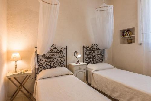 a bedroom with two beds and a table with a lamp at Trilocale 101-tia Maria Country Inn in Racale