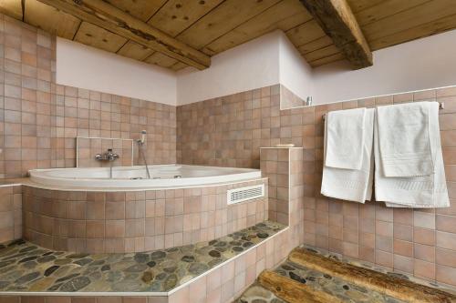 ein Badezimmer mit einer Badewanne, einem Waschbecken und Handtüchern in der Unterkunft Mayen2003 Ayent Anzère in Ayent