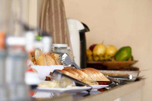 a table topped with plates of bread and fruit at Pousada Semente in Arraial d'Ajuda