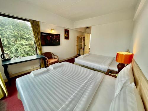 a hotel room with two beds and a window at MANGO Lagoon Place in Bangkok