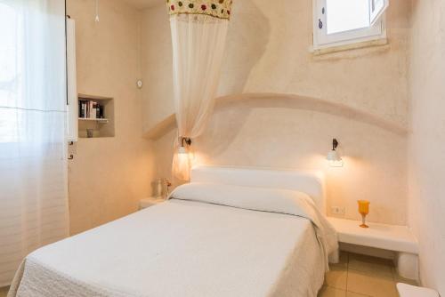 a bedroom with a white bed and a window at Bilocale 103-tia Maria Country Inn in Racale