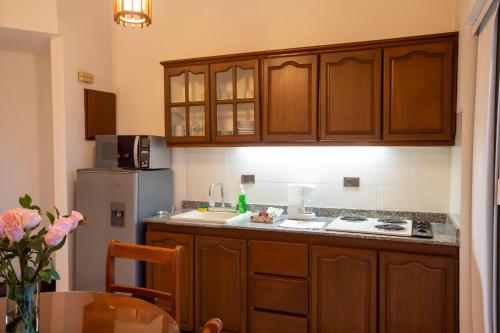 a kitchen with wooden cabinets and a refrigerator at Castellón de Juanambú in Cali