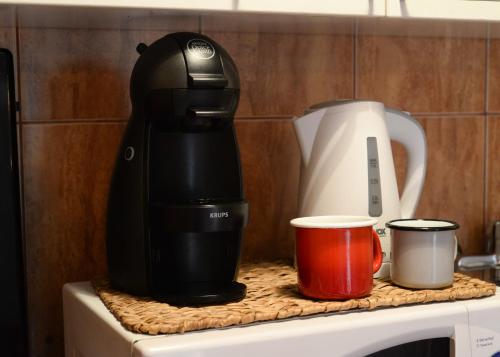 a coffee maker and two cups on a counter at Cabin & Apartment Kopaonik in Kopaonik