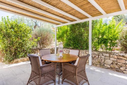 a patio with a wooden table and chairs at Bilocale 104-tia Maria Country Inn in Racale