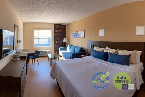 Habitación de hotel con cama y sala de estar. en Rio Vista Inn Business High Class Tampico en Tampico