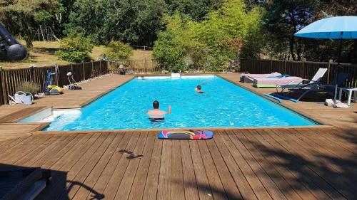 2 personnes nagent dans une piscine dans l'établissement Domaine de Bagnegrole, à Saint-Cyprien