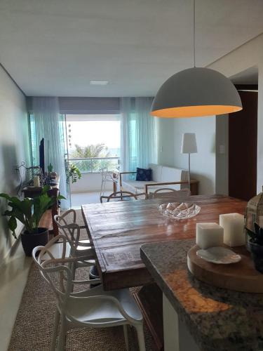 a living room with a wooden table and chairs at Assossego - Seu sossego a 200m do mar! in Ilhéus