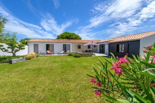 a house with a yard with pink flowers at La Cabane du pêcheur in La Couarde-sur-Mer