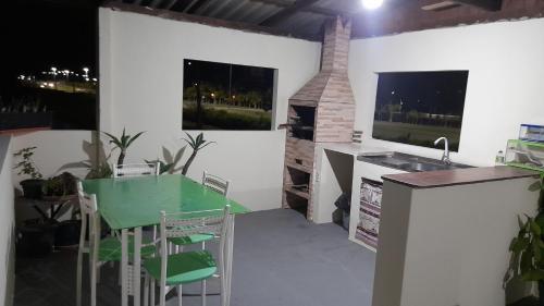 kuchnia z zielonym stołem i zlewem w obiekcie Suites Vista Do Parque w mieście Penha