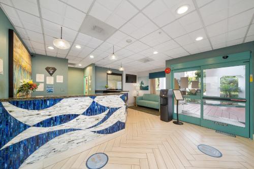 a lobby with a counter with a painting of a wave at Casablanca Inn in San Clemente