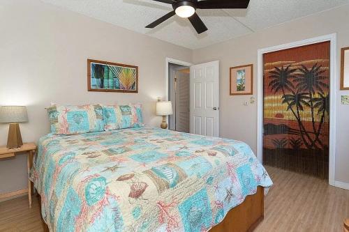 a bedroom with a large bed and a ceiling fan at Enjoy the sunset at OCEAN FRONT 1BR Apartment - pool on site! in Kailua-Kona