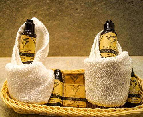 two bottles of alcohol in a basket with towels at Casa Azul Maya in Isla Mujeres