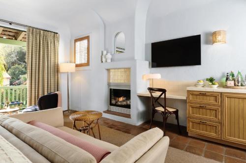 a living room with a couch and a fireplace at Palihouse Santa Barbara in Santa Barbara