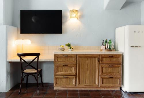 a kitchen with a wooden island with a tv on the wall at Palihouse Santa Barbara in Santa Barbara