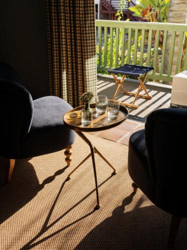 a living room with a table and a chair and a balcony at Palihouse Santa Barbara in Santa Barbara