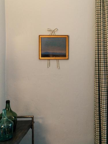 a picture on a wall with a vase on a table at Palihouse Santa Barbara in Santa Barbara