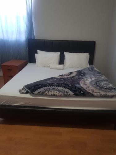 a bed with a black headboard and white sheets and pillows at SALAMA LODGE in Cape Town