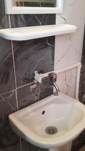 a bathroom with a sink and a mirror at Esin Pansiyon in Tokat
