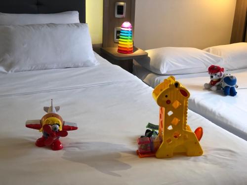 two beds with stuffed animals and toys on them at Novotel São Paulo Berrini in São Paulo