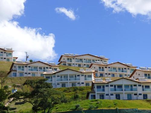 a row of apartment buildings on a hill with trees at MIRANTE ESCARPAS APTO 702 in Capitólio