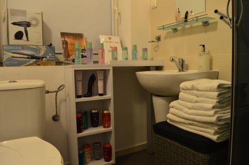 a bathroom with a sink and a toilet and towels at The White House Austria in Lind ob Velden