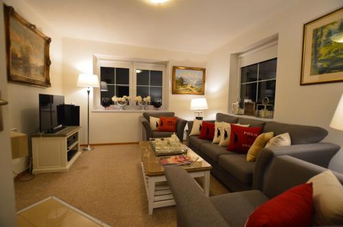 a living room with a couch and a tv at The White House Austria in Lind ob Velden