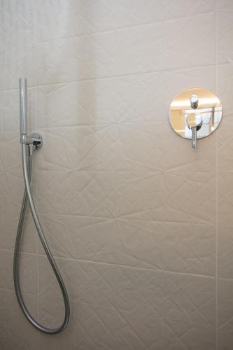 a shower with a hose attached to a wall at Bellamania B&B in Anacapri