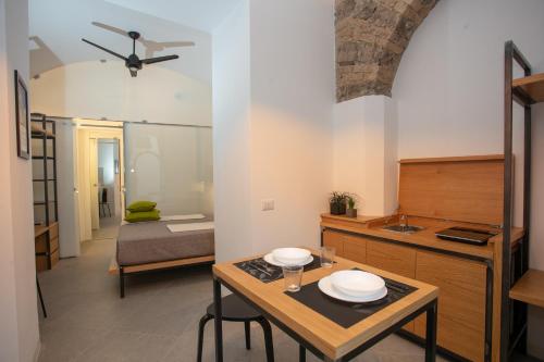 a kitchen and living room with a table with plates on it at Bellamania B&B in Anacapri