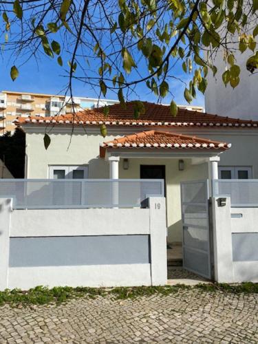 a white fence in front of a white house at GetWet Surfcamp in Costa da Caparica