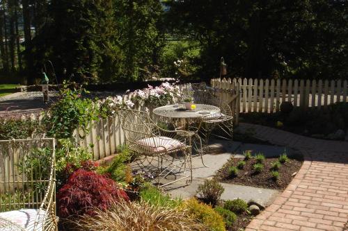 a patio with a table and chairs in a garden at Littlebank Country House in Settle