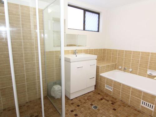 a bathroom with a tub and a sink and a shower at The Breakers 10 in Forster