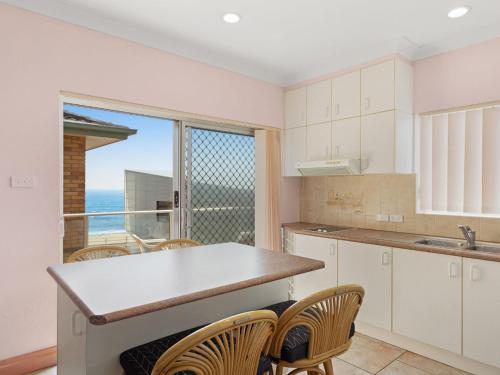 a kitchen with a table and chairs and a window at Debra Court 11 in Forster