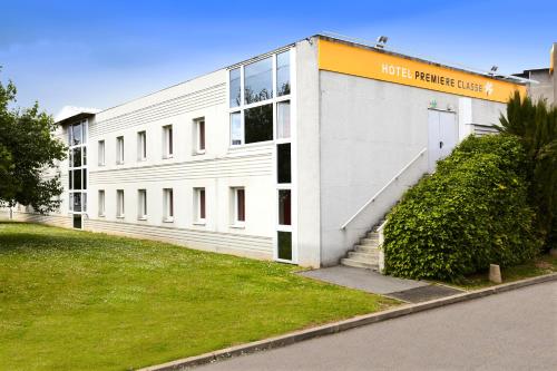 a white building with a sign on the side of it at Premiere Classe Roissy CDG - Paris Nord 2 - Parc des Expositions in Roissy-en-France