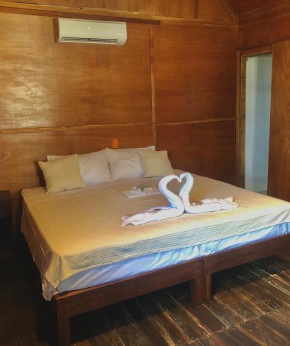 a bed with two white towels on top of it at Papitos Bacalar Hotel and Marina in Bacalar