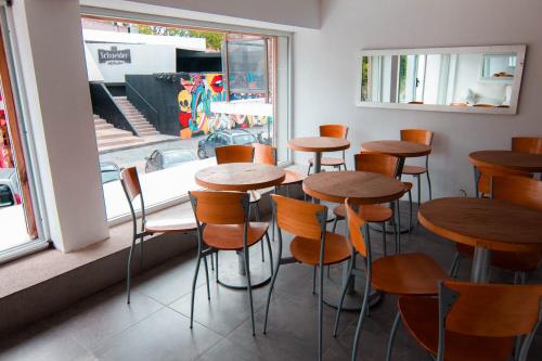 una fila de mesas y sillas de madera en un restaurante en Hotel Alfa, en Villa Gesell