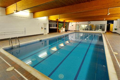 a large swimming pool in a building at Eight Acres Hotel in Elgin