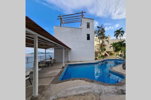 a house with a swimming pool next to a building at 64 Peninsula del Capitan in Manzanillo