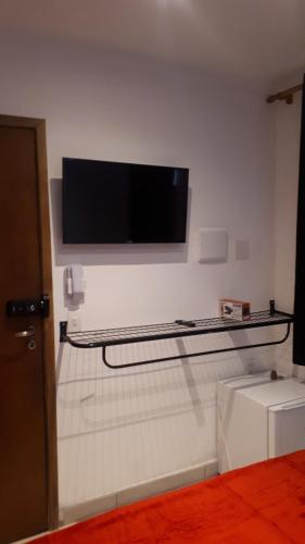 a flat screen tv hanging on a wall at Pippo Suites Guarujá in Guarujá