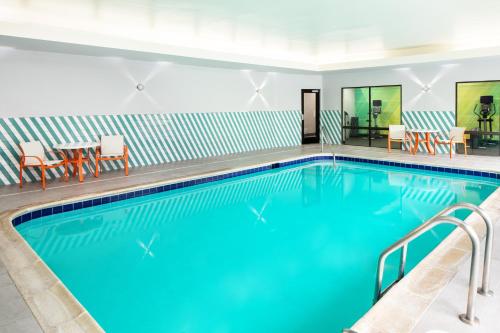 a pool at a hotel with chairs and tables at Holiday Inn Cheshire - Southington by IHG in Southington