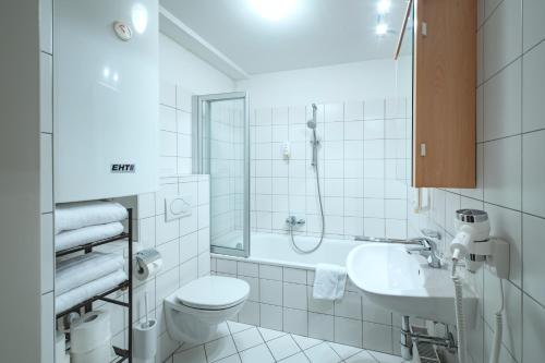 a white bathroom with a toilet and a sink at Basic Apartments downtown in Innsbruck