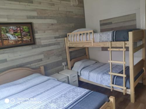 2 literas en una habitación con paredes de madera en Hostal del Viajero, en Valparaíso