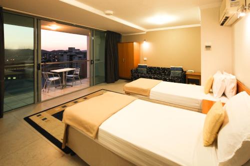 Habitación de hotel con 2 camas y balcón en Astor Metropole Hotel en Brisbane