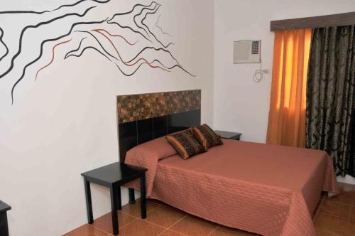 1 dormitorio con 1 cama con una pintura en la pared en Date & Dine Resort en Antipolo