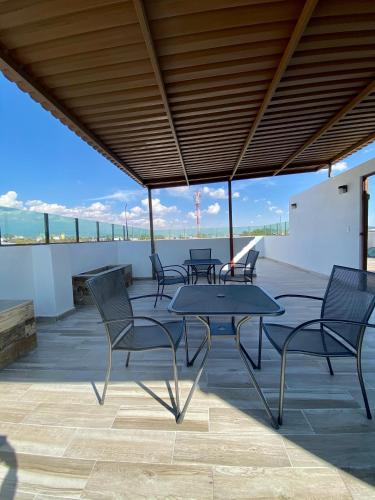 a patio with tables and chairs on a roof at Hotel Maria Sofia ViaCapu in San Felipe Hueyotlipan