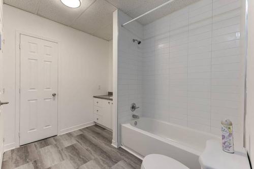 a white bathroom with a tub and a toilet at Le 1066 - Logement spacieux à Limoilou in Quebec City