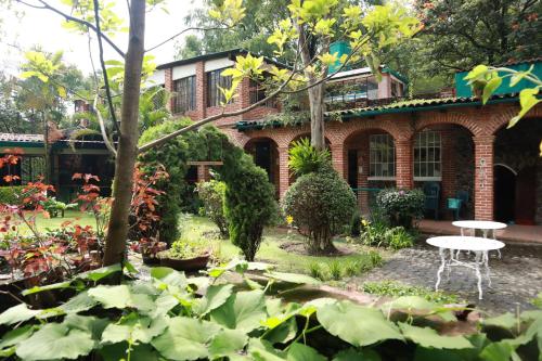 a garden in front of a brick building at Hotel La Posada del Valle in Tepoztlán